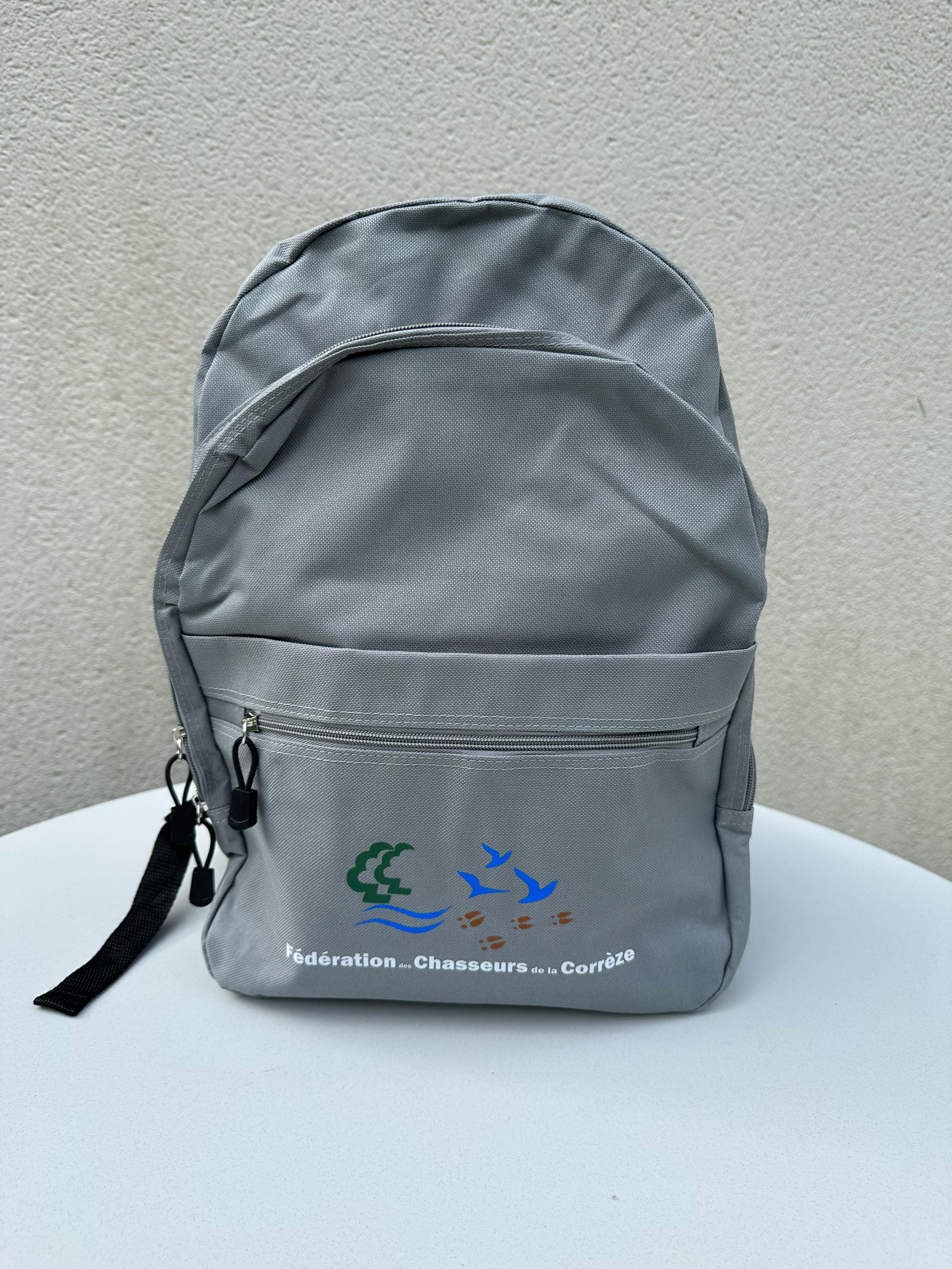 Sac à dos gris en toile avec le logo de la Fédération des Chasseurs de Corrèze