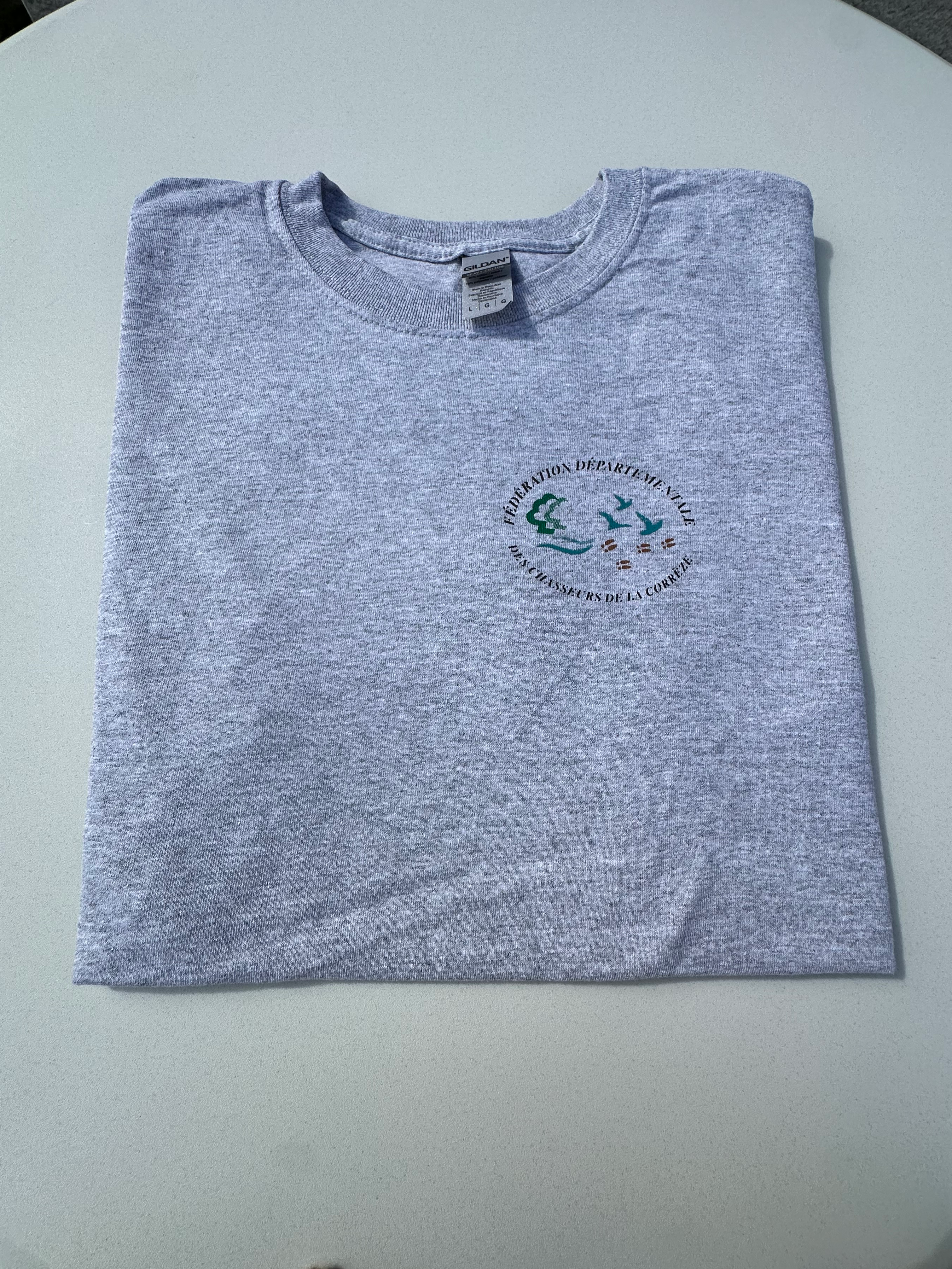 Tee-shirt gris avec le logo de la Fédération des Chasseurs de Corrèze à l'avant et "Le bonheur de chasser en Corrèze" au dos